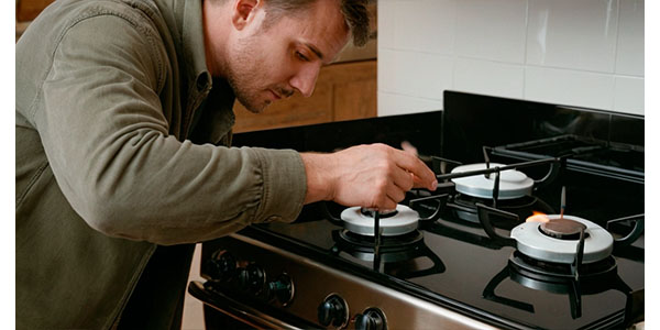 мужчина устанавливает газовую плиту