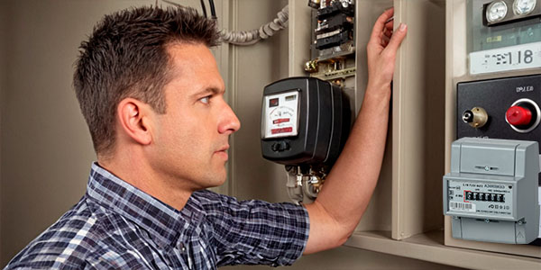 мужчина смотрит на электрический счетчик