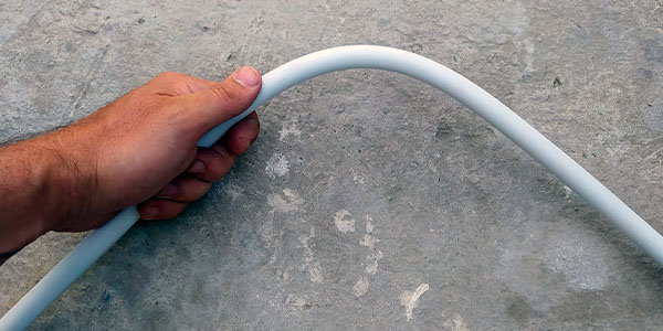 человек гнет металлопластиковую трубу