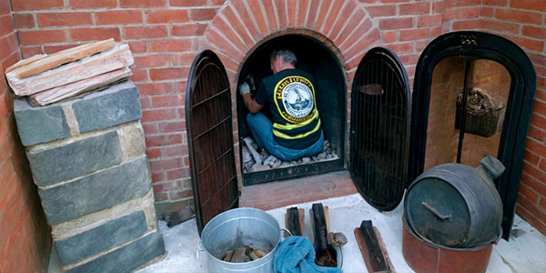 мужчина чистит камин и дымоход