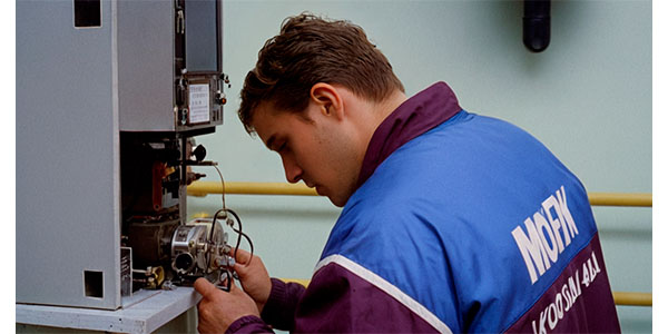 парень осматривает газовый котел